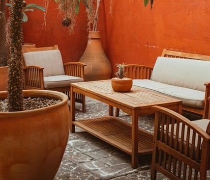 Elegant stamped concrete patio with orange background and wooden furniture