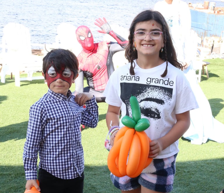Kids posing with a pumpkin balloon