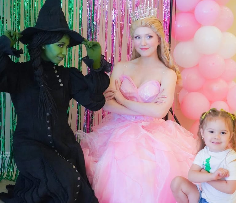 Elphaba and Glind pose with a child
