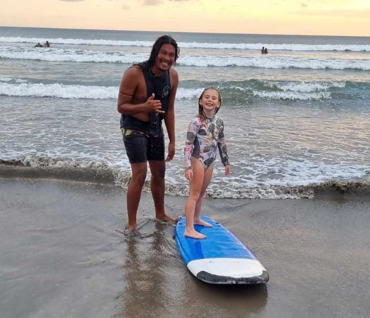 a woman and her daughter standing in the water