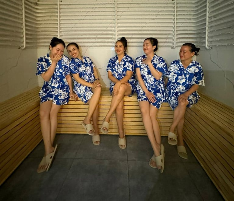 a group of women in blue dresses sitting on a bench ina cold room