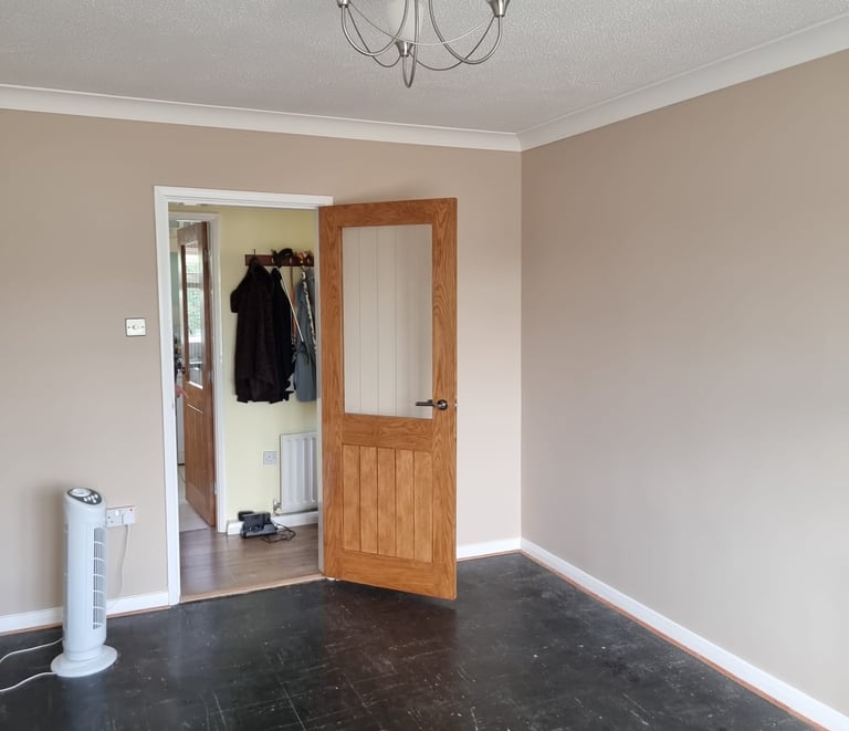 An unfurnished room, with painted mauve walls, white ceiling, coving, skirting, and doorframe.