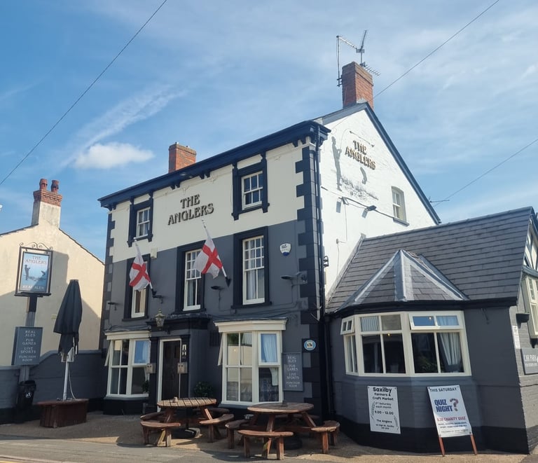 The painted-grey, brick exterior of a pub named The Anglers.