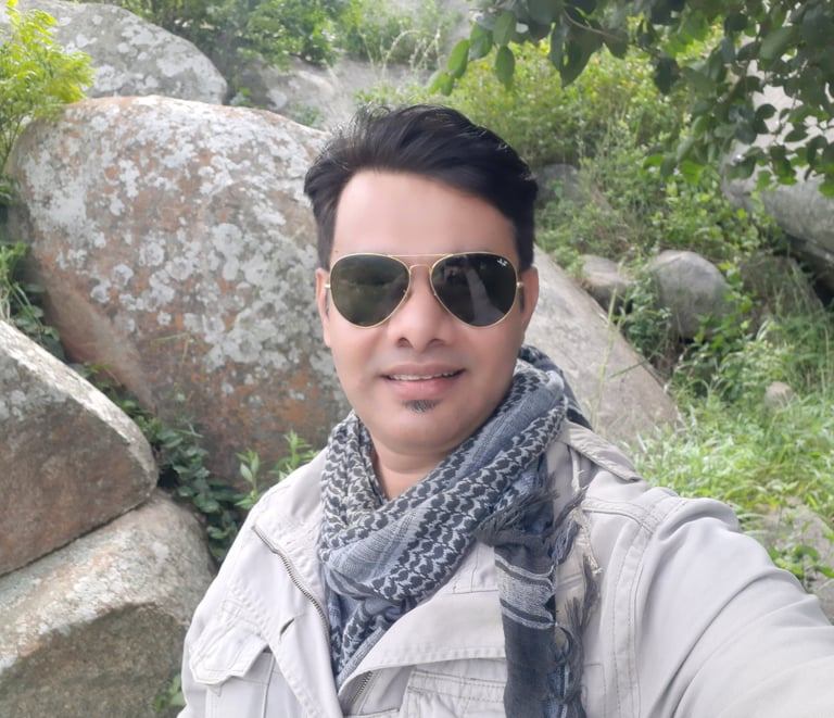 a man in sunglasses and a scarf around his neck, raheel ahmed