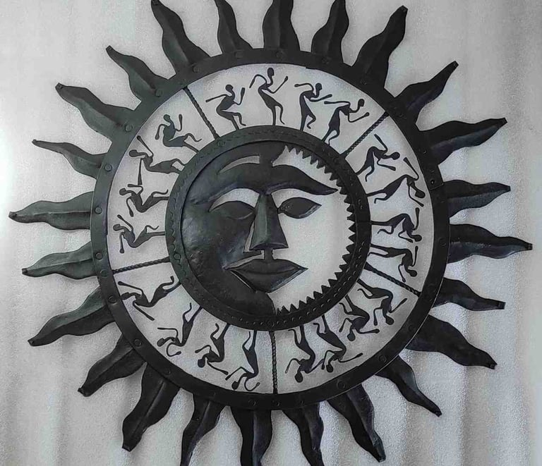 "Handcrafted iron wall art featuring sun face and dancing tribal figures–Bastar decor-for global markets"