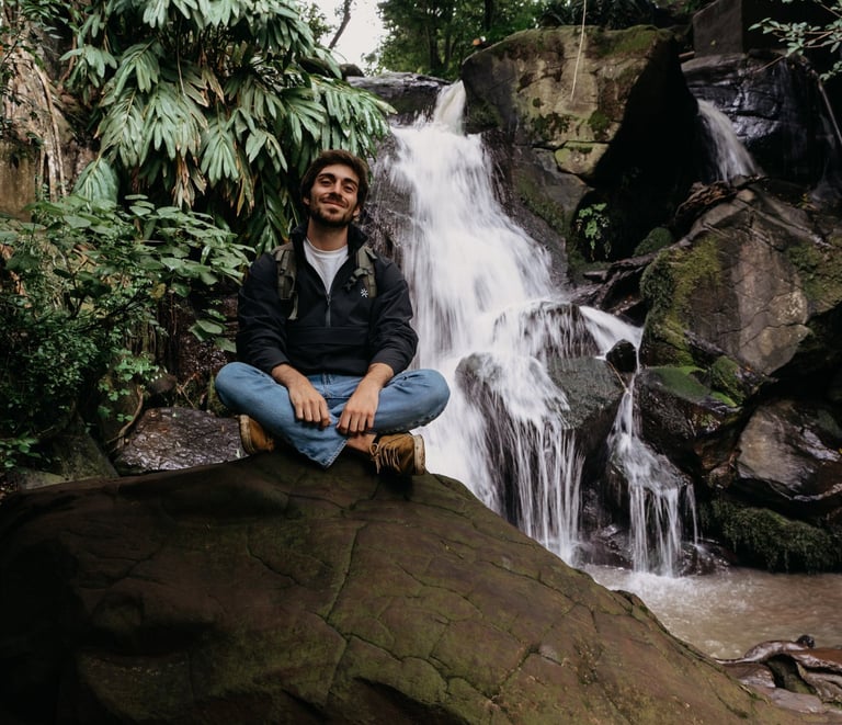 sitting on a rock in front of a waterfall in Nairobi