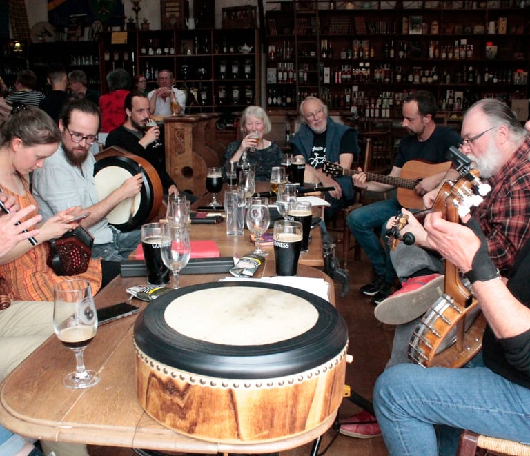 Musicians playing traditional folk music with guitars, banjo, and bodhrán drum in an Irish pub.