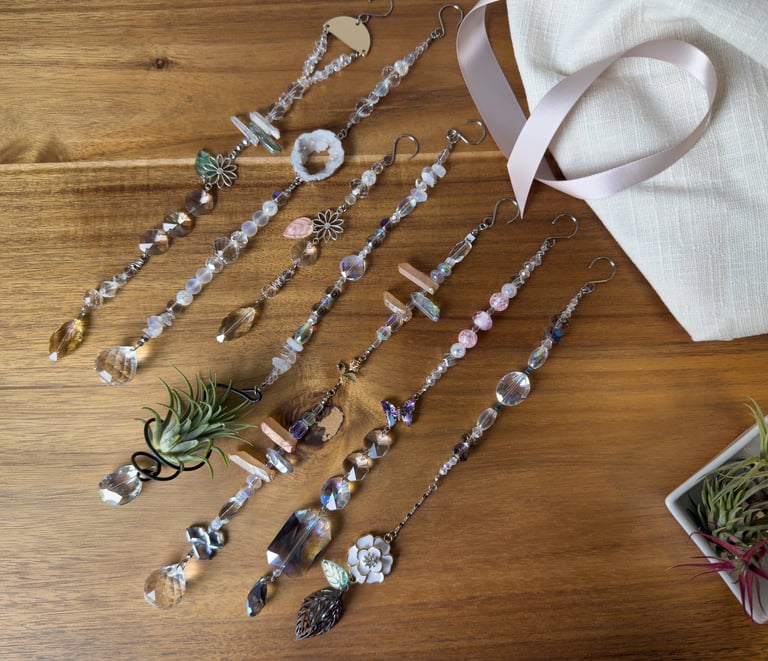 Handmade elegant crystal beaded suncatchers with glass prisms displayed on a wooden surface.