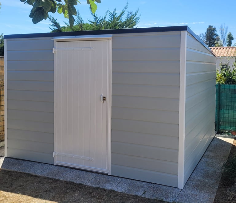 abri en ossature bois, posé sur dalle béton, porte PVC, charnières alu, bardage PVC rigide., toit monopente  en bac acier