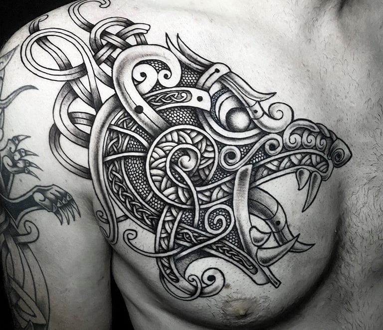 Tatouage viking et celtique d'une tête d'ours sur le pectoral.