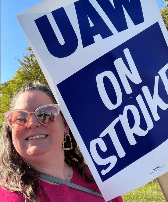 Woman in sunglasses holding strike sign