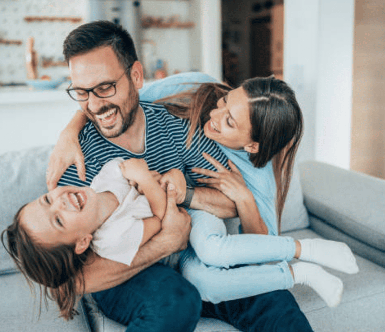 a man and woman sitting on a couch with a baby martin pe coach de parejas