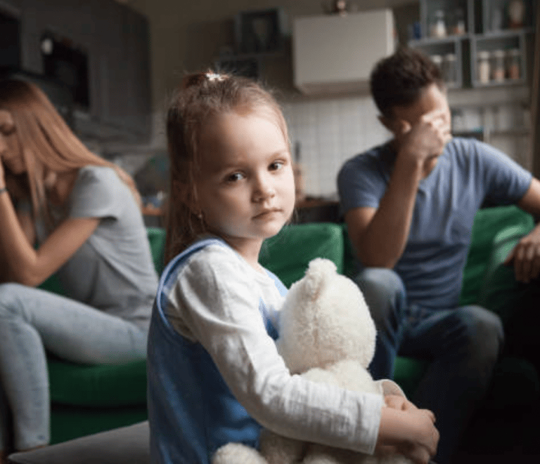 a young girl sitting on a couch with her father and mother martin pe coach de parejas