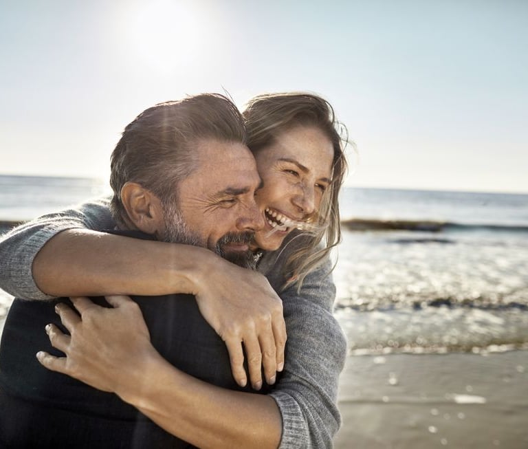a man and woman embracing on the beach martin pe coach de parejas