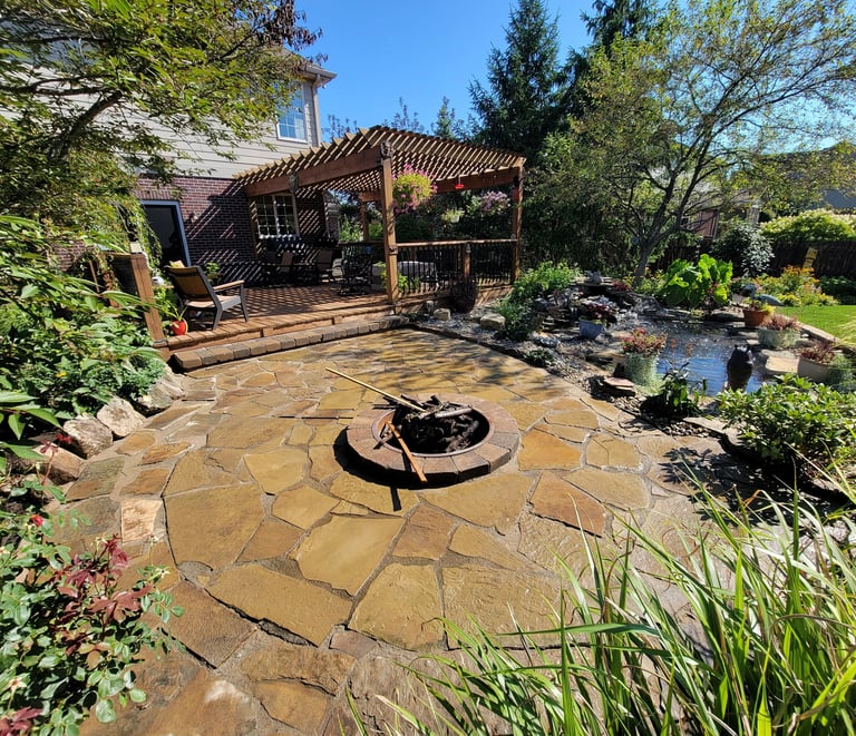 A fire pit in a backyard with a custom paver patio and pergola