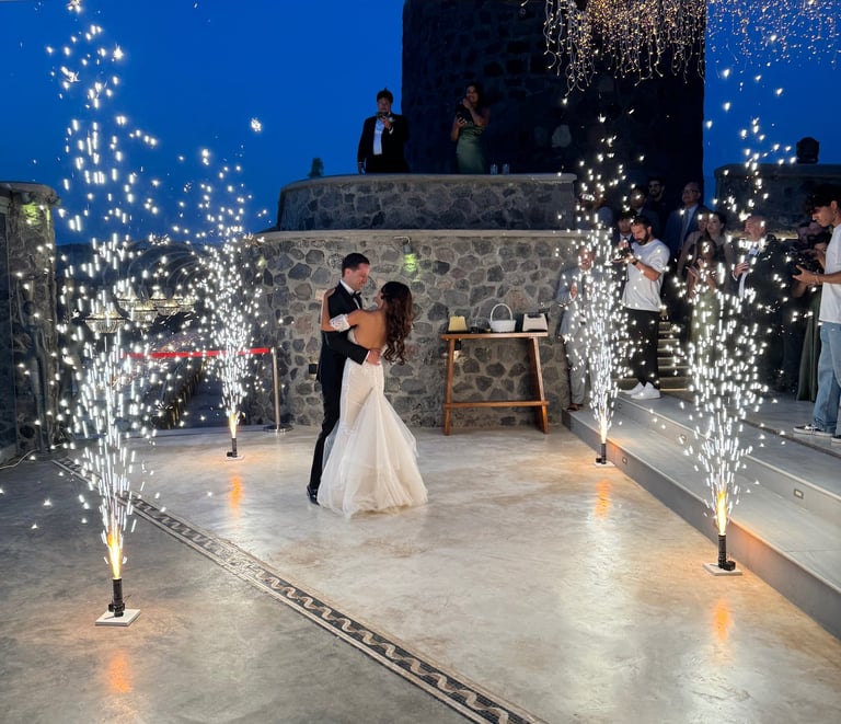 Memorable first dance moment illuminated by synchronized stage fireworks.