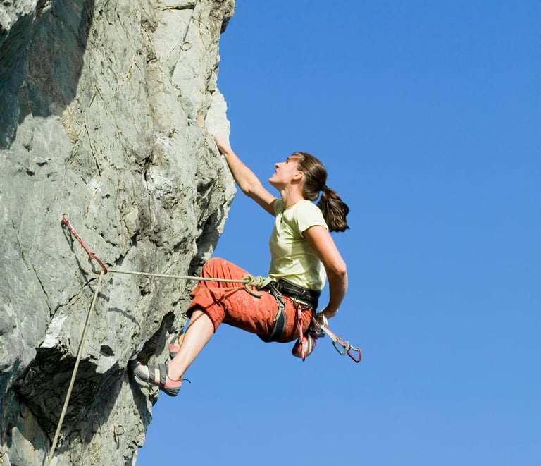 a woman climbing a rock face 