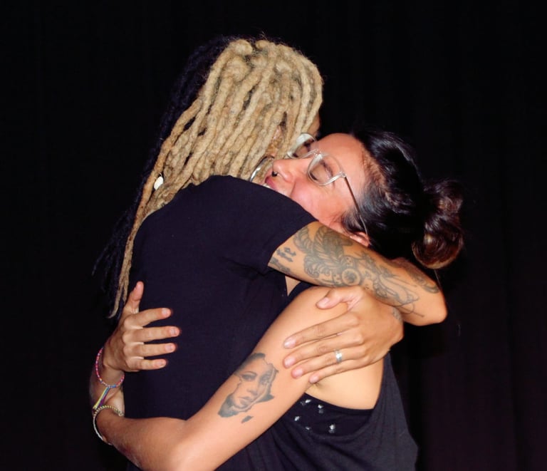 Actriz afro con rastas abraza a su compañera