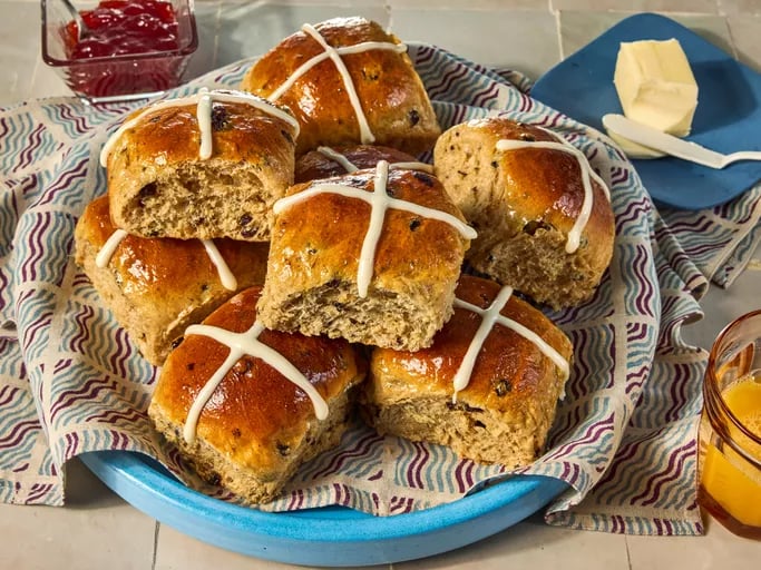 Traditional spiced, sticky glazed fruit buns with pastry crosses