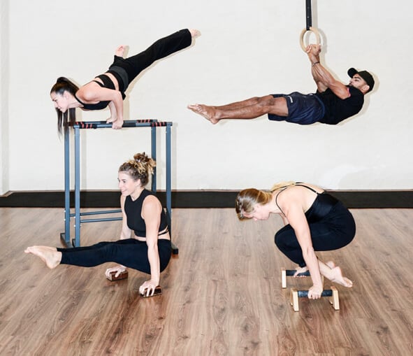 vier mensen doen verschillende acrobatische poses, kracht training, handstand, calisthenics in Gent