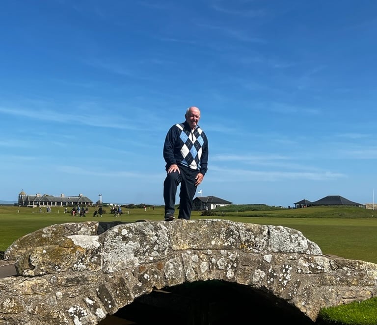 a man standing on a stone bridge over a stream