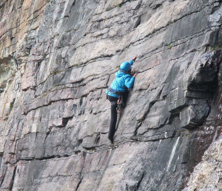 a person climbing a rock face on a cliff