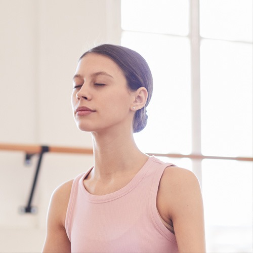 Jeune femme sereine et détendue qui pratique la relaxation dynamique de Caycedo