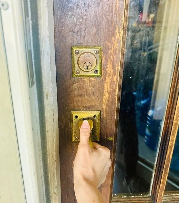 Hand on home door during lockout— representing emergency residential service locksmith in Candler, NC