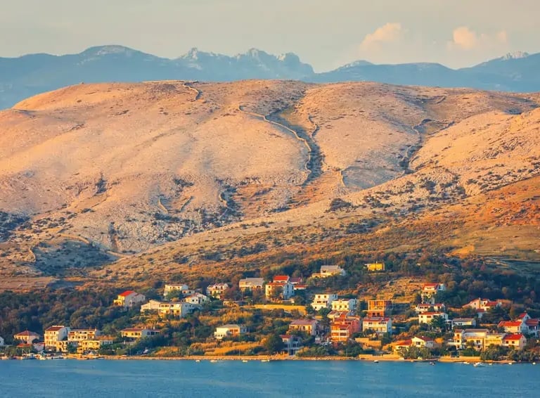 Pogled na selo na otoku Pagu okruženo brdima.
