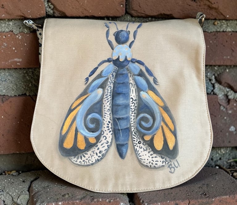 Papillon bleu peint à la main sur sac besace