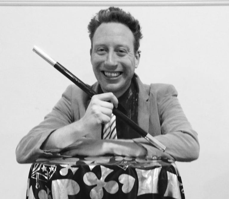 a man in a suit and tie is smiling and holding a knife and knife
