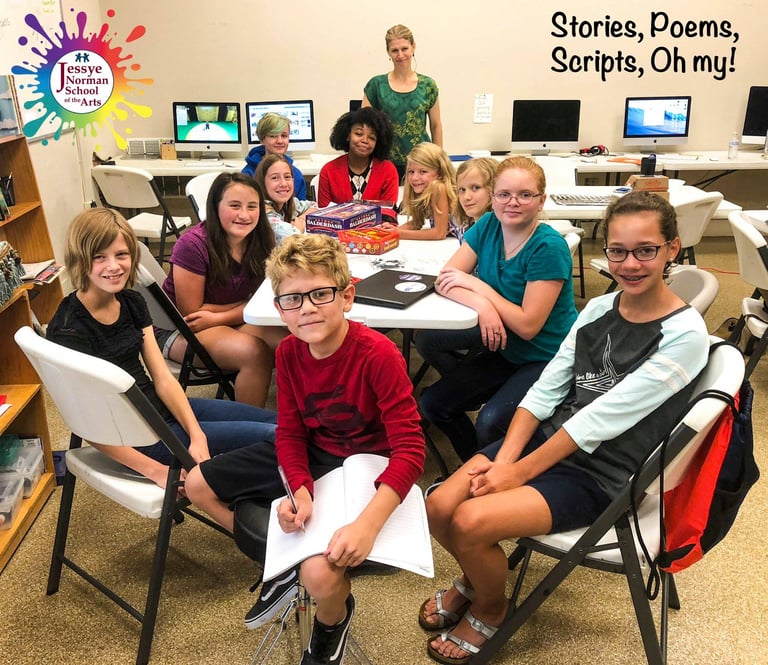 Group of children at table pose for photo with Sea Stachura at Jessye Norman School of the Arts