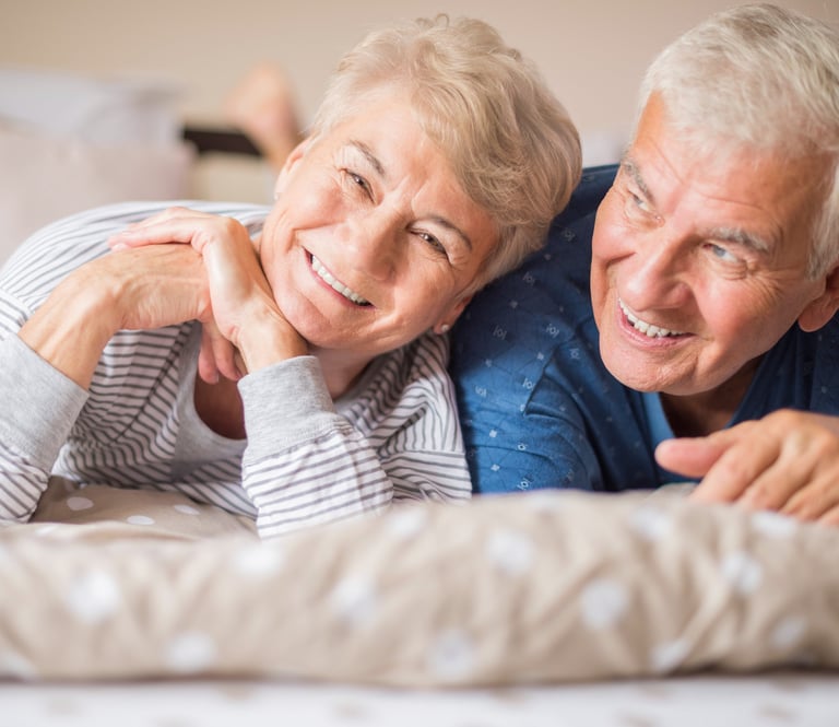 Casal de idosos sorrindo, ilustrando que a terapia floral é segura para todas as idades.