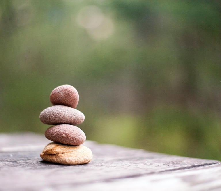 Gestapelde stenen in balans, symbool voor evenwicht tussen digitalisering en menselijkheid.