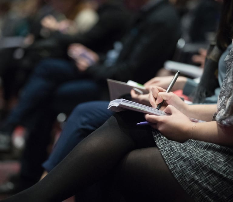 Woman taking notes at a conference
