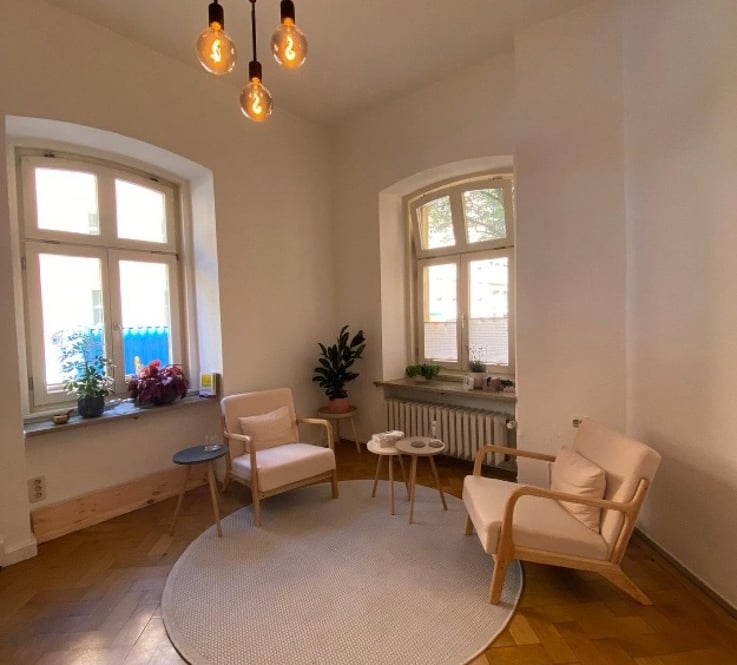 Schöner Praxisraum mit zwei Stühlen und Parkettboden in einem Altbau
