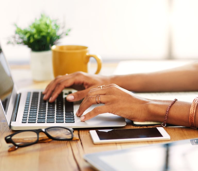 a woman's hands typing on a laptop computer