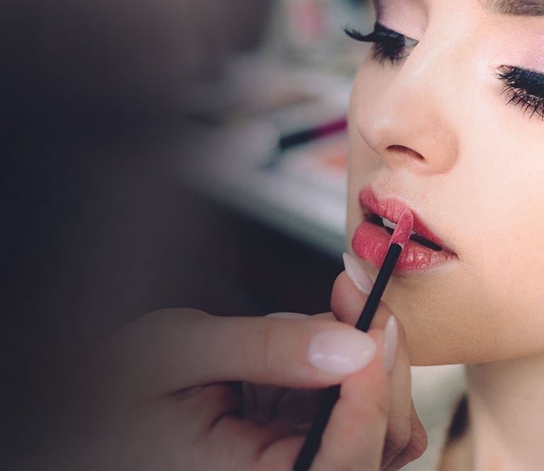 women recieving cosmetic application  of lipstick and facial