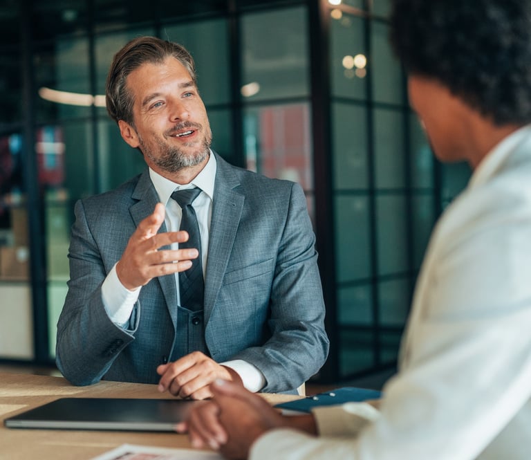Professional businessman in a grey suit leading an executive interview in a modern office.
