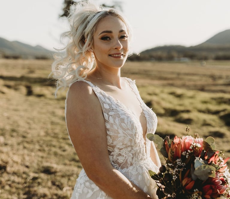 a woman in a wedding dress standing in a field