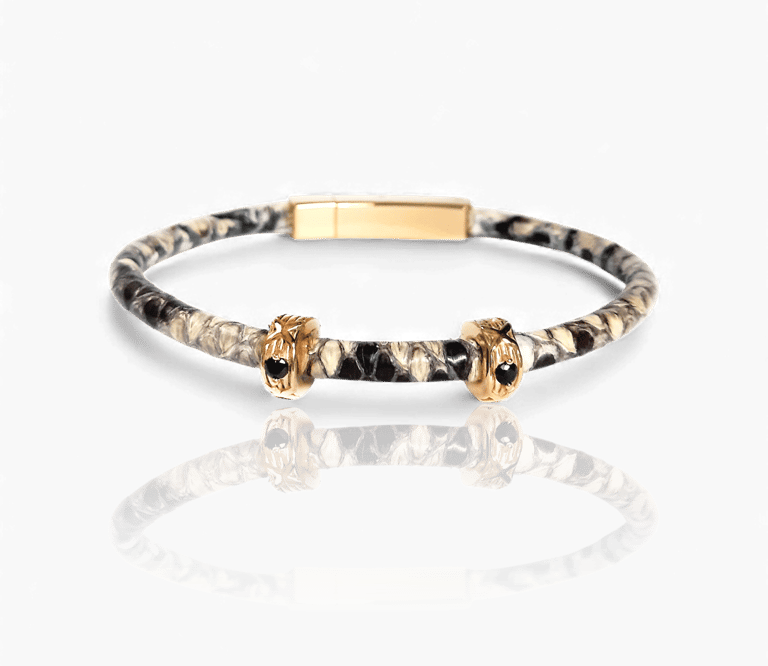 Luxury snakeskin leather bracelet featuring gold charms with black gemstones on a white background.