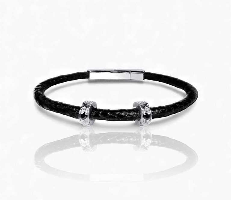 Handcrafted black braided leather men's bracelet with silver skull charms and magnetic clasp.