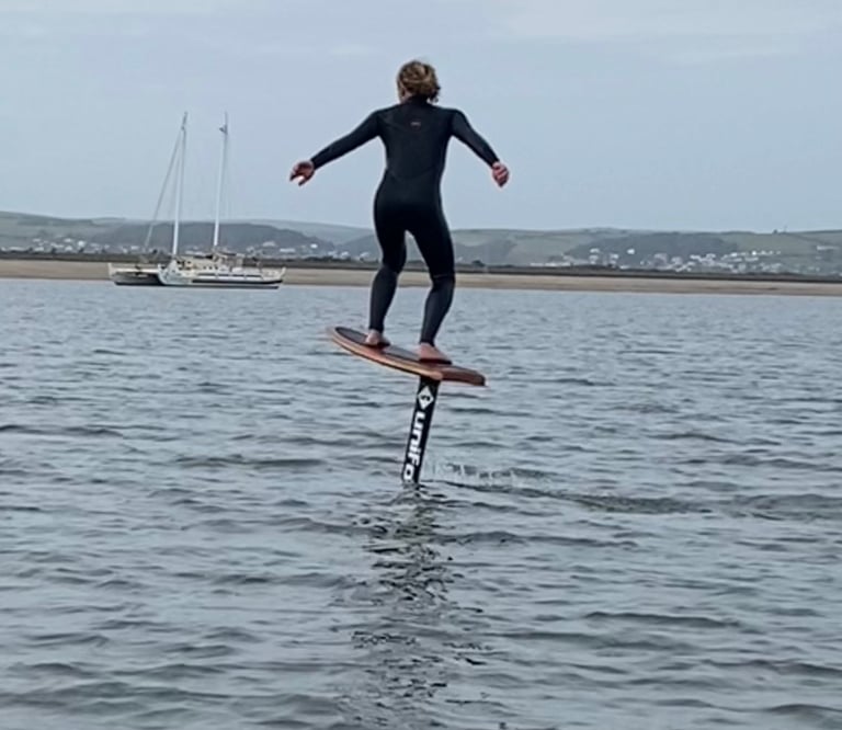 Foiler pumping across the estuary on a foil board