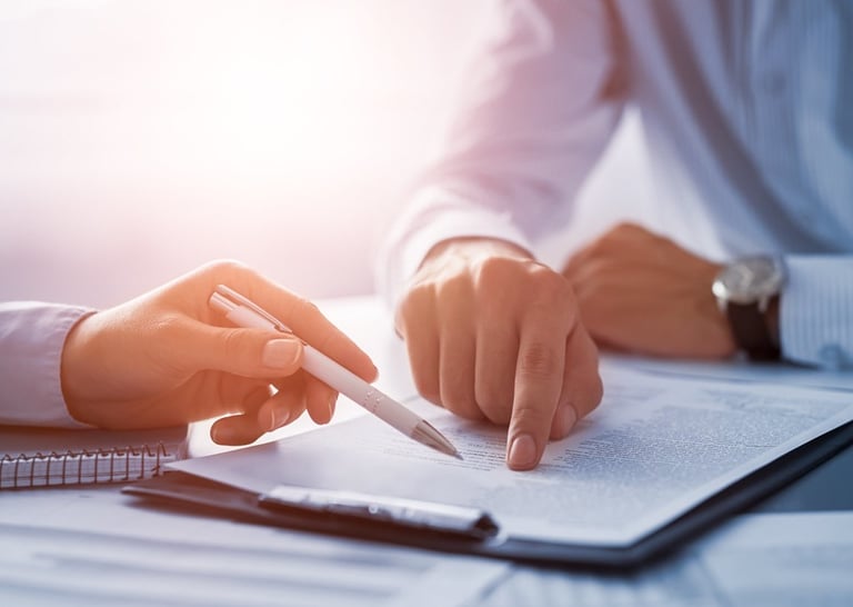 A business professional points to a legal document during a contract signing or consultation.