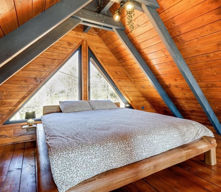 a bed in a loft apartment with a wooden floor