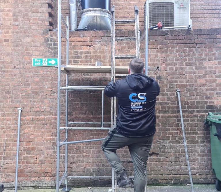 a man in cs cleaning and ducting company  workwear  fixing ducting