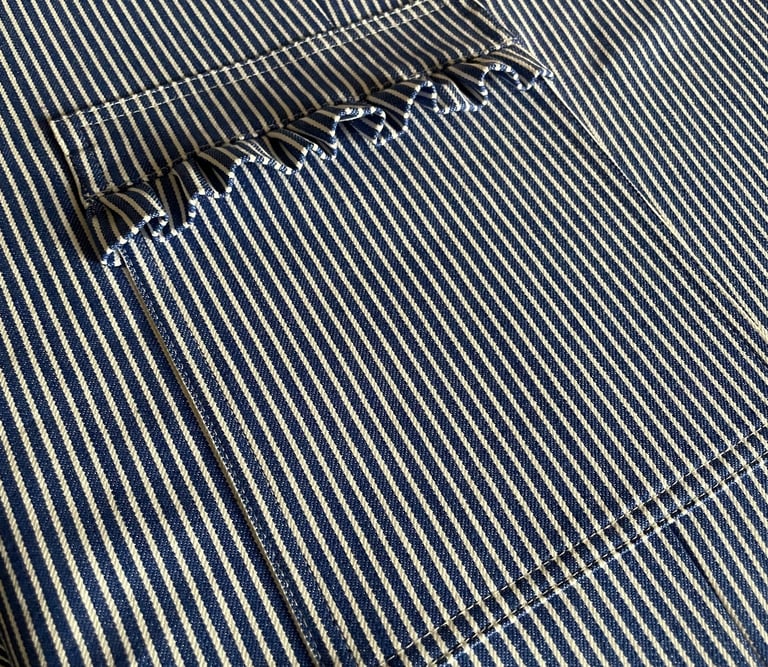 lomme på skrædder overall i blå og hvid stribet denim med frynser