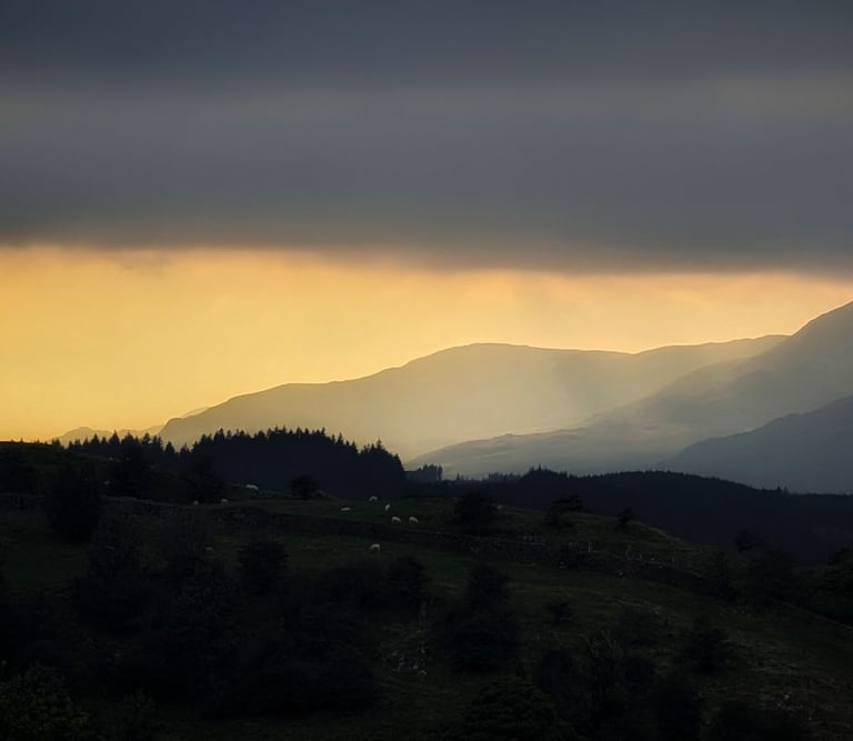 Sunset over mountains with Autumn light and haze in the Lake District Near Ambleside