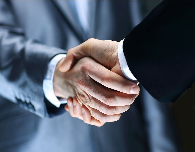 a man in a suit and tie is shaking hands