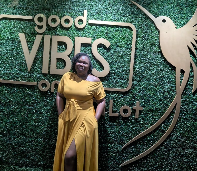 a woman in a yellow dress standing in front of a sign that says good vibe